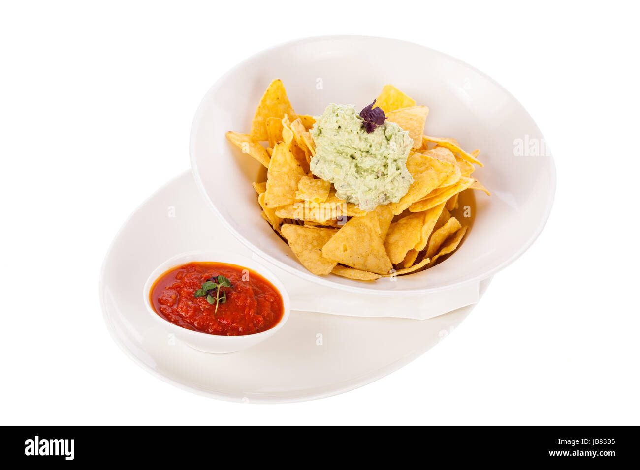 Mais Chips nachos guacamole und mit einer schale salsa dipp dans isoliert auf einem Teller Hintergrund weißem vor Banque D'Images
