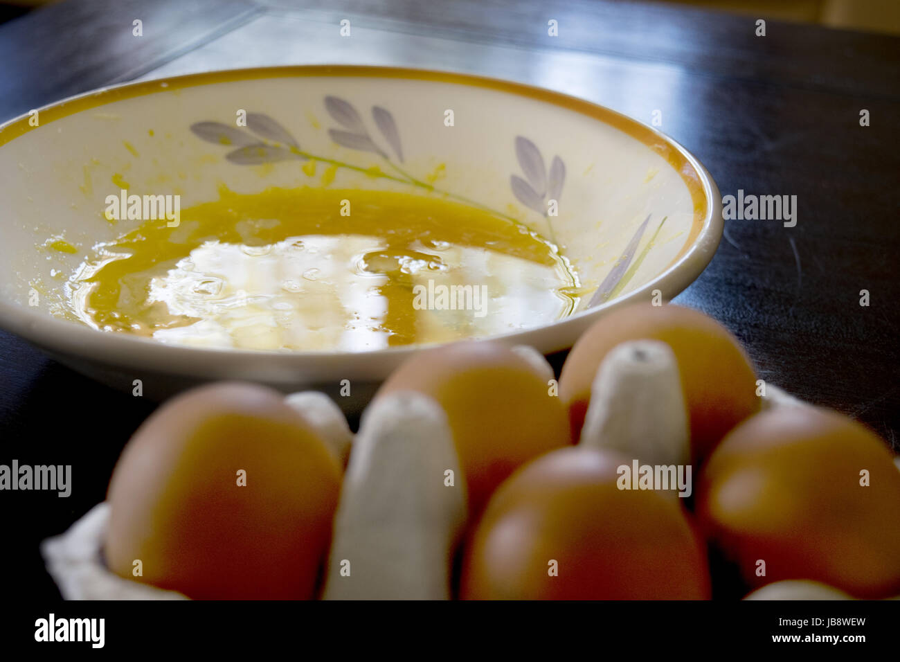 Les oeufs battus dans une assiette blanche dans la pénombre Banque D'Images