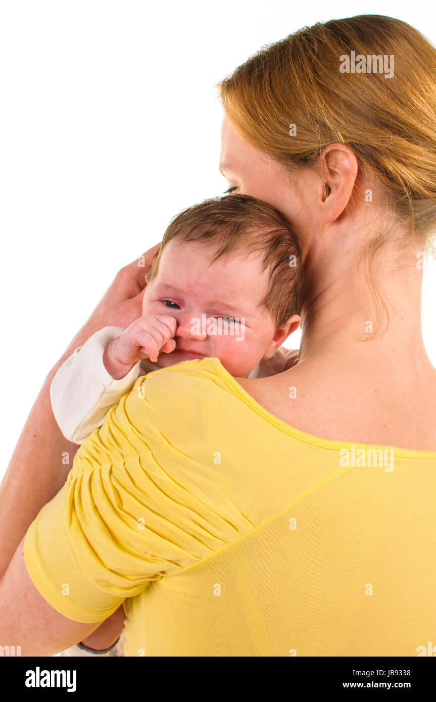 Mutter hat ihr neugeborenes Baby auf der Schulter, Die kleine reibt sich die augen, freigestellt Hintergrund weißem vor. Banque D'Images