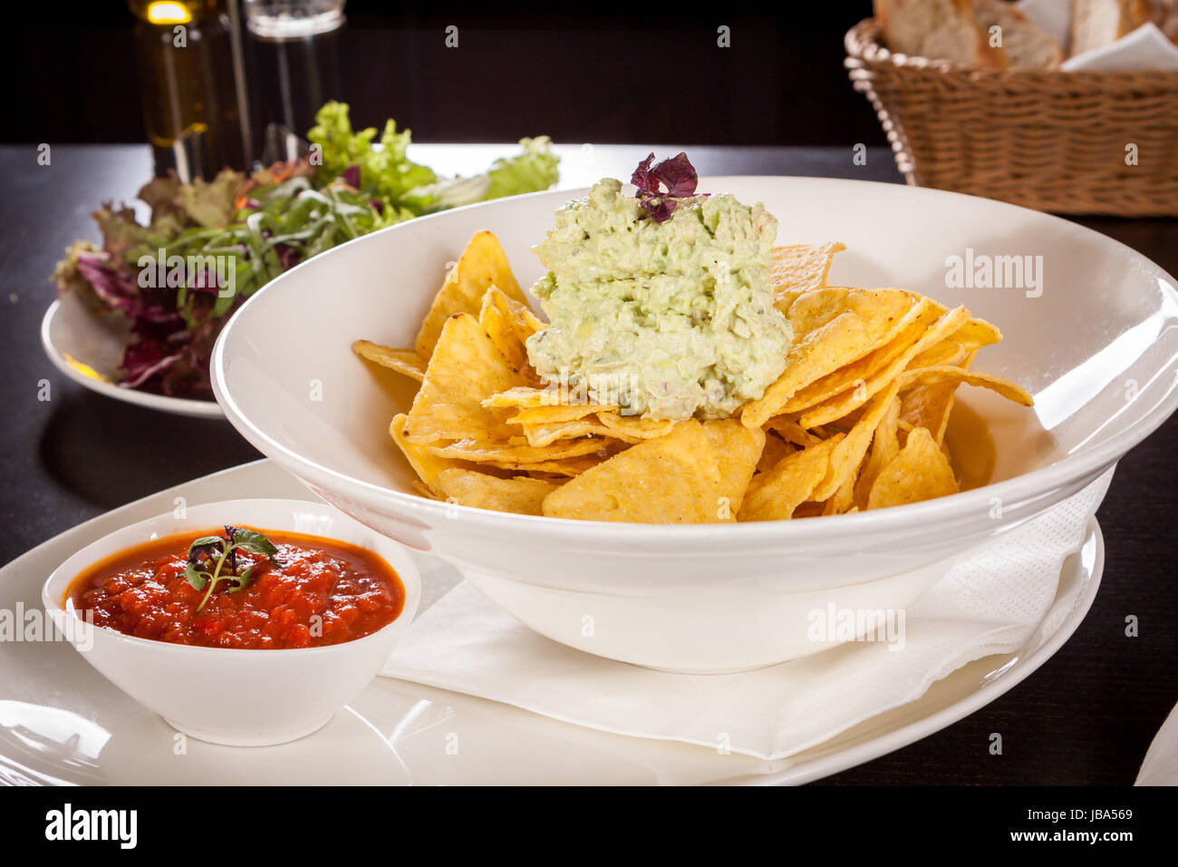 Mais Chips nachos guacamole und mit einer schale salsa dipp dans auf einem Teller Banque D'Images