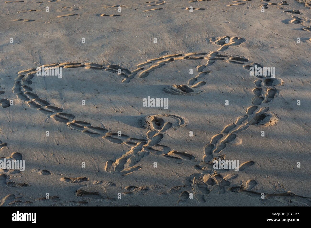Coeur sur le sable fait avec des empreintes Banque D'Images