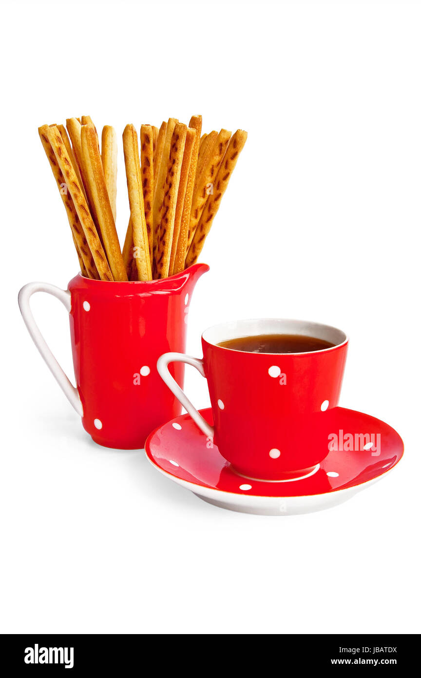 Bâtonnets de pain et café dans l'ustensile rouge isolé sur fond blanc Banque D'Images