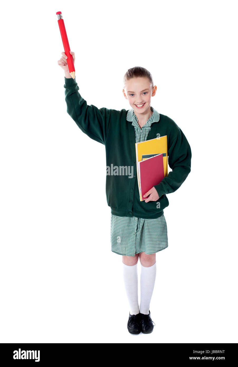 Jolie fille montrant un crayon vers le haut avec des livres dans sa main Banque D'Images