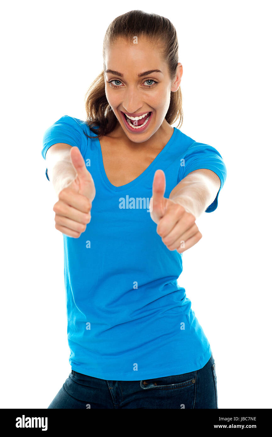 Heureux woman standing against white background et montrant le double Thumbs up. Banque D'Images