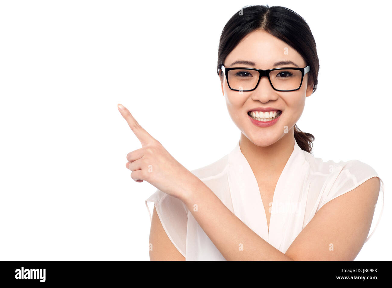 Young cheerful girl avec lunettes dirigés à l'écart sur fond blanc Banque D'Images