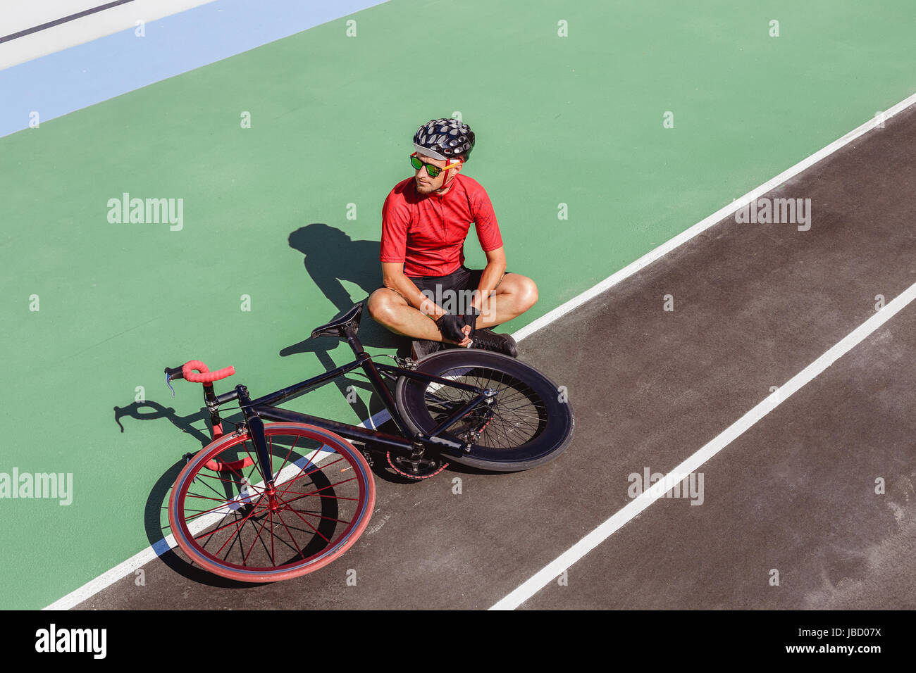 Avec l'athlète noir un vélo au vélodrome Banque D'Images