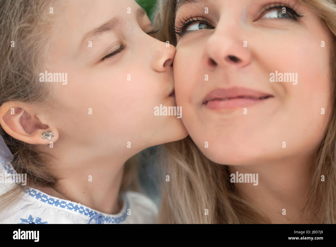 Petite fille baisers une heureuse mère. Close-up portrait. Banque D'Images