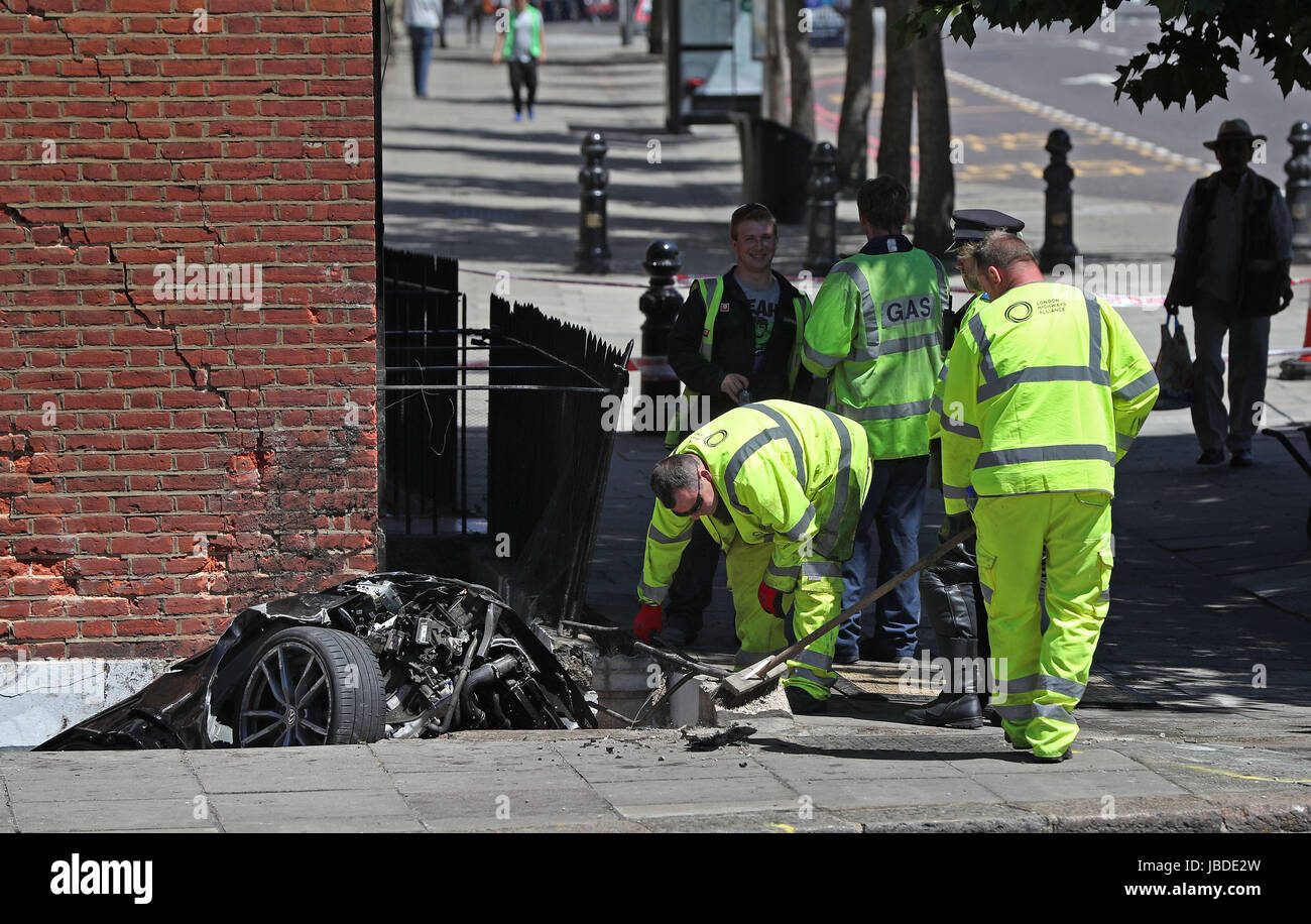 Nettoyer les travailleurs des lieux d'un accident de voiture à Kensington, Londres, où un homme est décédé après une voiture s'est écrasé dans un sous-sol d'une maison à tel qu'il a filé au loin à partir de la police. Banque D'Images