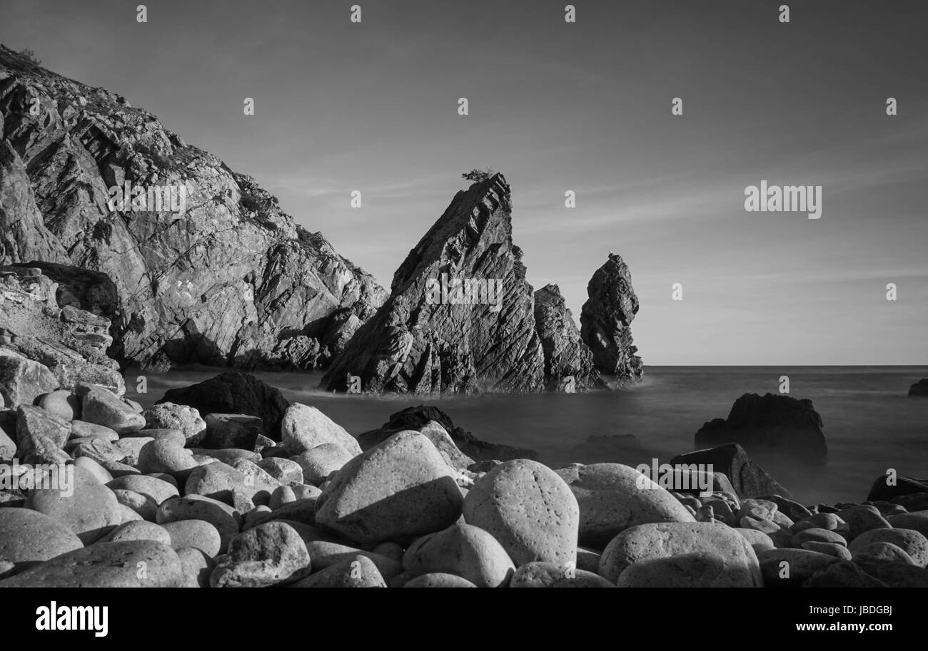 Rock sauvage incroyable plage au coucher du soleil. Parc Naturel de Sintra Cascais Portugal Banque D'Images