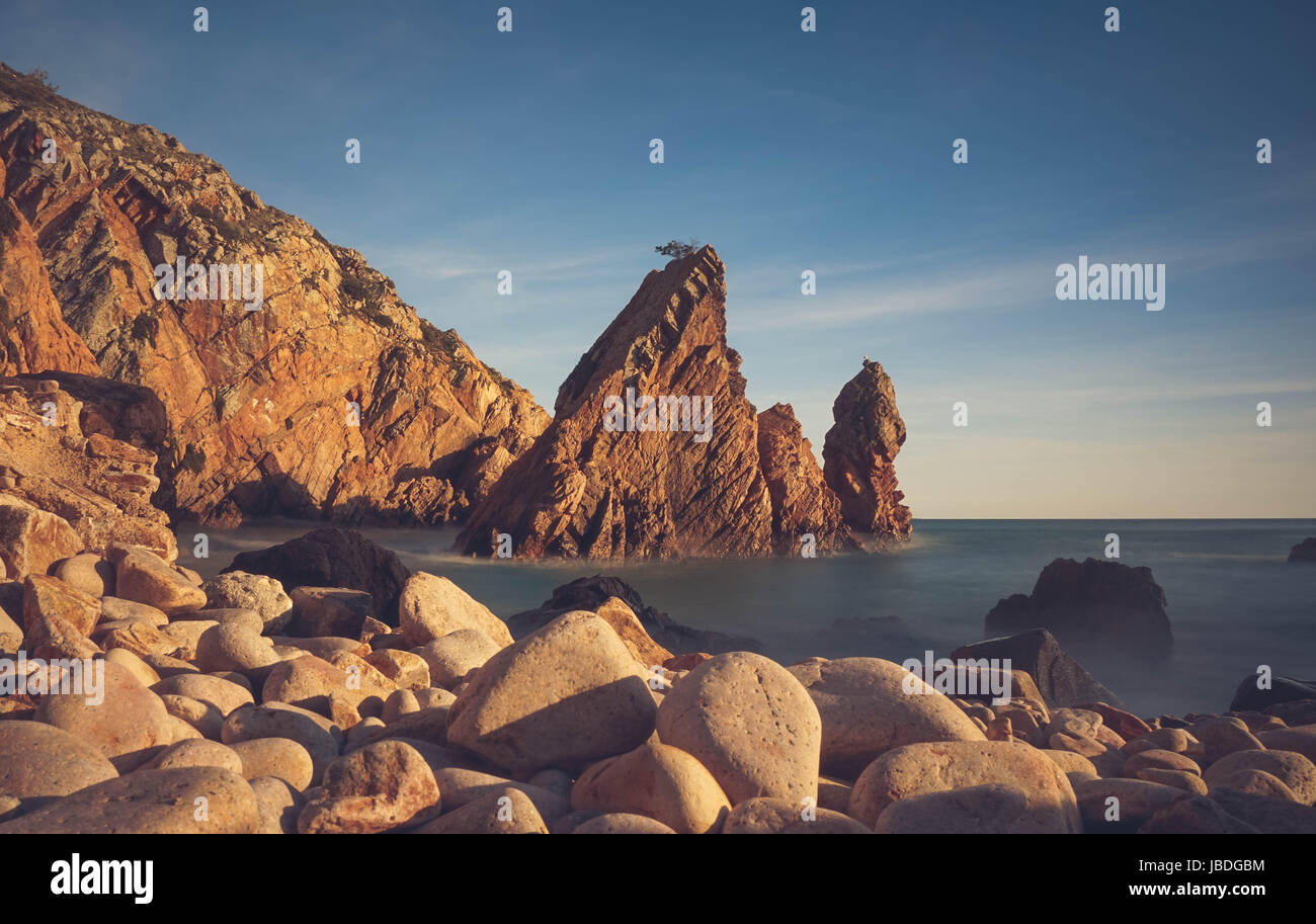 Rock sauvage incroyable plage au coucher du soleil. Parc Naturel de Sintra Cascais Portugal Banque D'Images