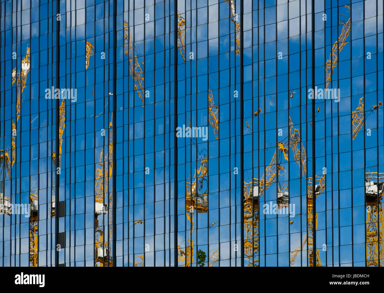 Concept de l'industrie de la construction - grues et chantier de réflexion dans le nouveau bâtiment Banque D'Images