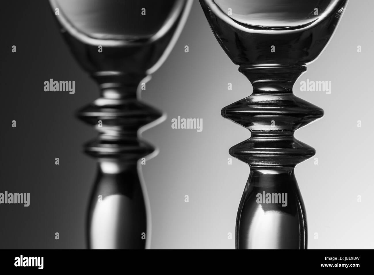 Vue détaillée de l'adjacent au centre de deux verres de champagne avec gradient de luminosité à l'arrière-plan ; Monochrome. Banque D'Images