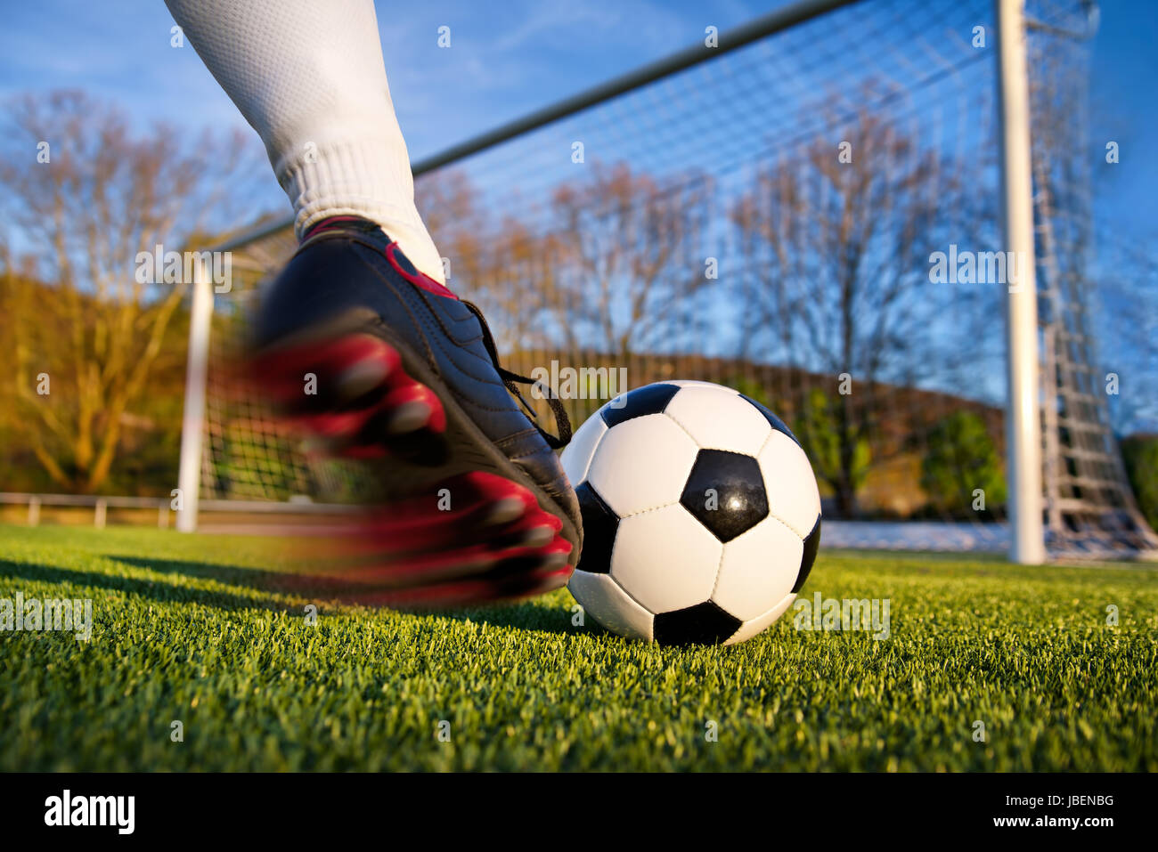 Fußballer kickt den Ball in Richtung Tor, natürlicher Basis Hintergrund Banque D'Images