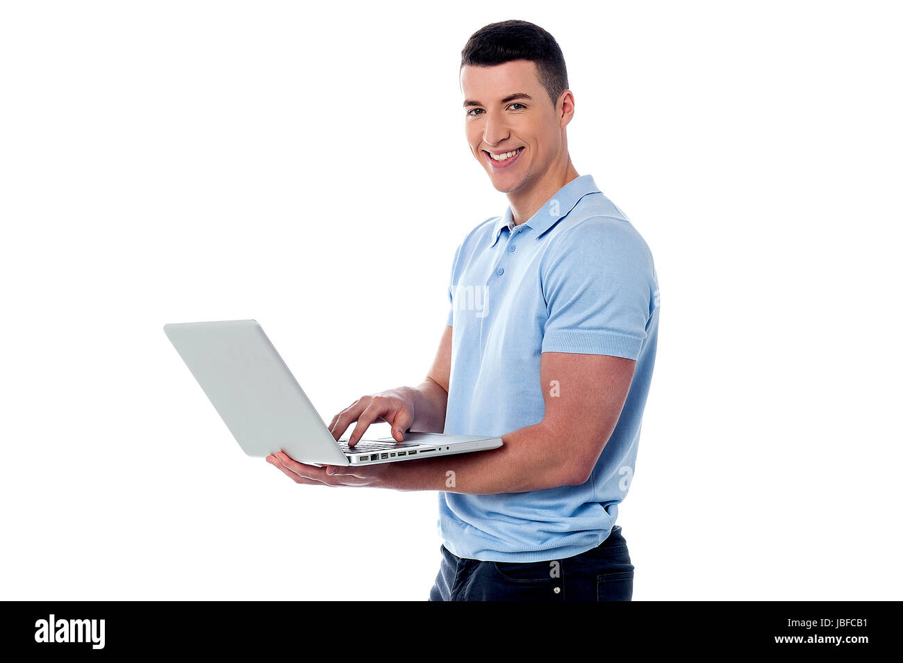 Smiling guy naviguant sur son ordinateur portable Banque D'Images