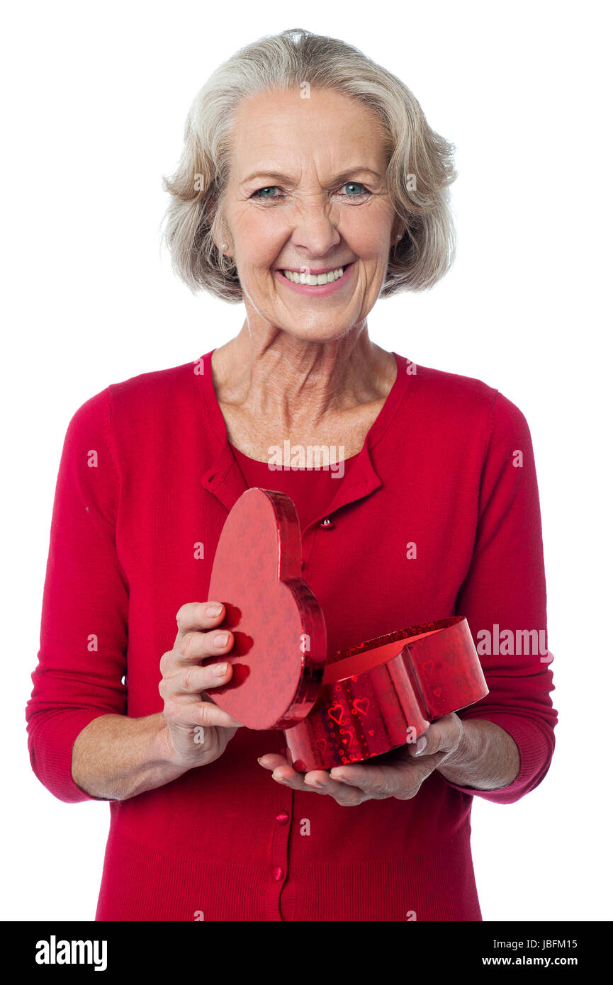 Jolie femme âgée tenant son cadeau saint valentin Banque D'Images