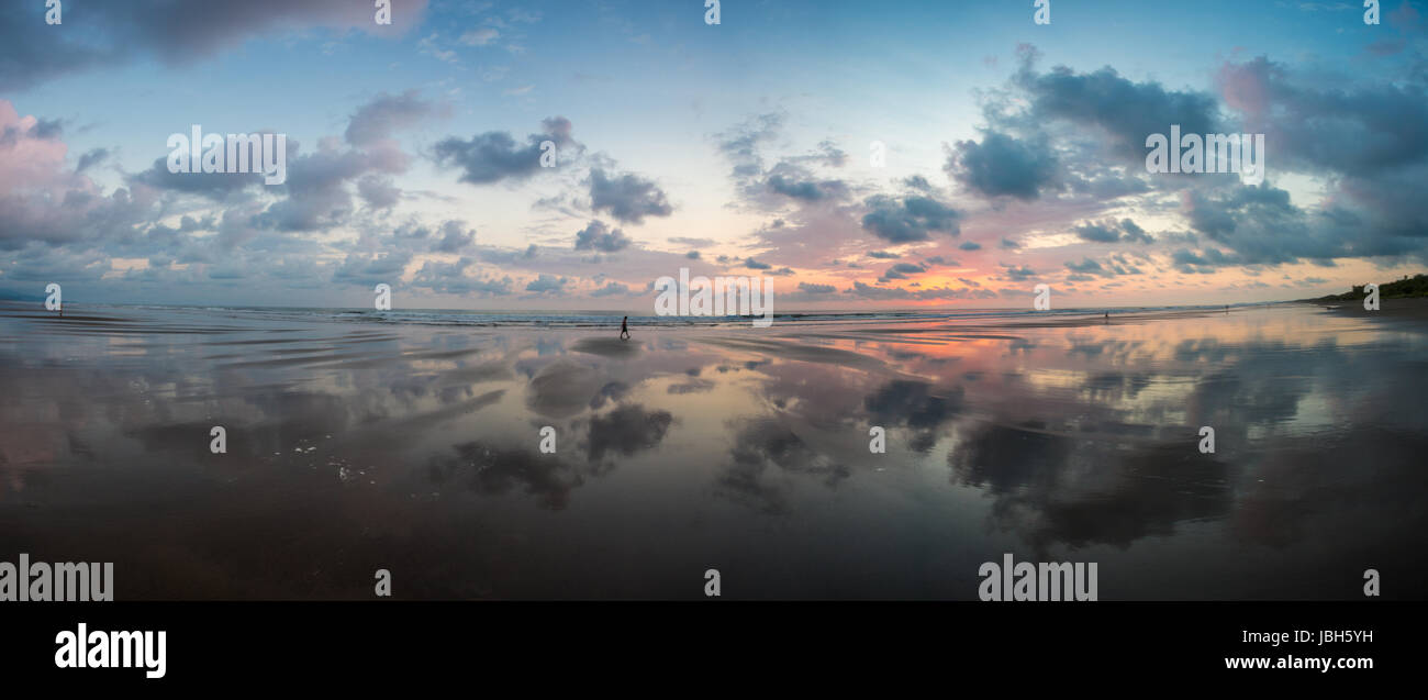 Vue du coucher de soleil sur la plage de Matapalo avec silhouette de personnes ayant une marche, le Costa Rica. Matapalo est situé dans le sud de la côte du Pacifique. Les principales attractions sont le surf et l'éco-tourisme, Costa Rica 2013. Banque D'Images