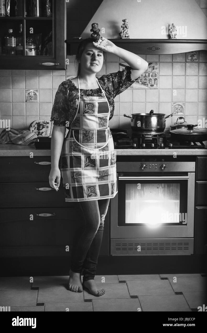 Photo en noir et blanc de cuisine ménagère fatigué sur permanent Banque D'Images