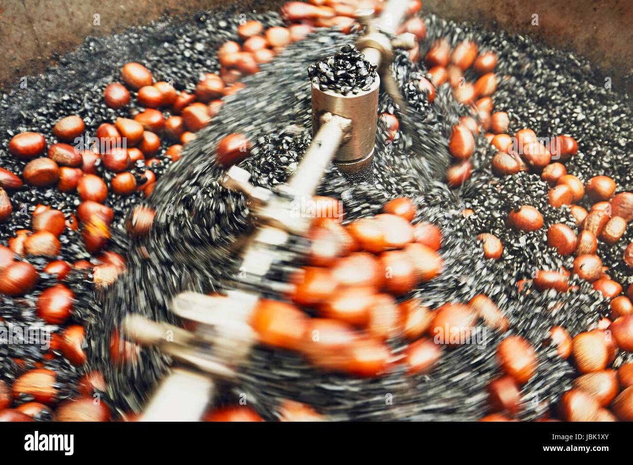 Préparation des châtaignes grillées sur le marché de rue à Kuala Lumpur - blurred motion Banque D'Images