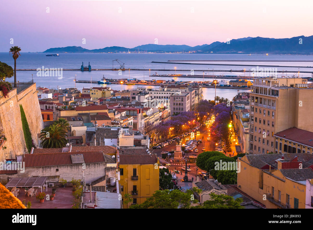 La ville de Cagliari, vue sur les toits à la tombée de l'artère principale à Cagliari -le Largo Carlo Felice - et le port de la ville au loin, la Sardaigne. Banque D'Images