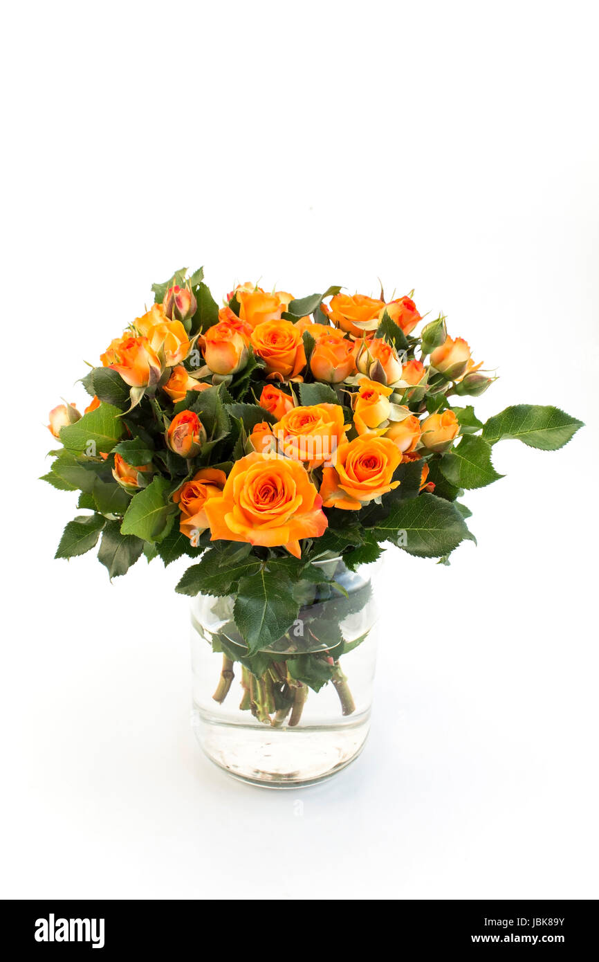 Bouquet de roses orange dans un vase de verre. Banque D'Images