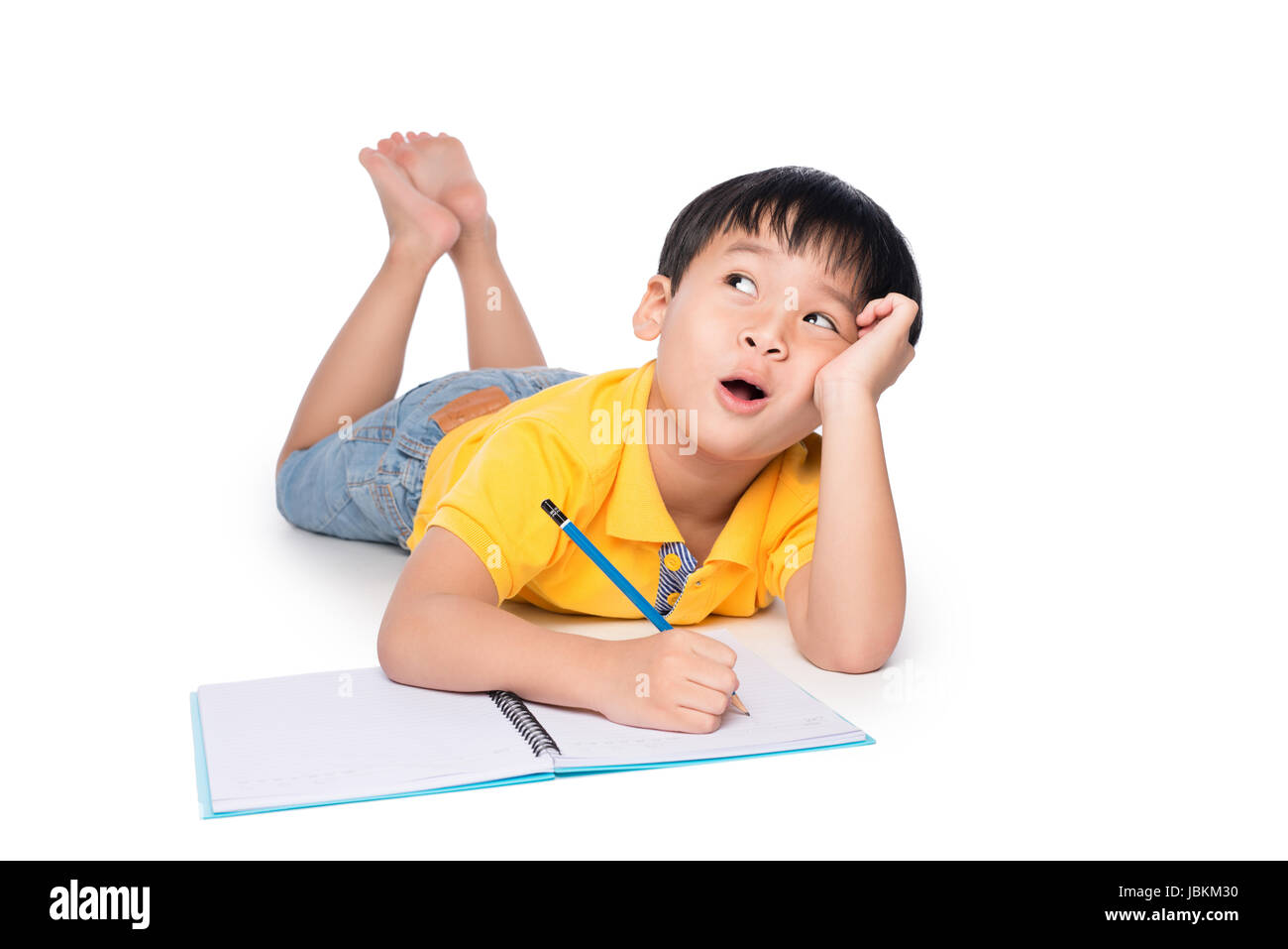 Écolier allongé sur un marbre, jusqu'à la recherche et l'écriture dans l'ordinateur portable. Banque D'Images