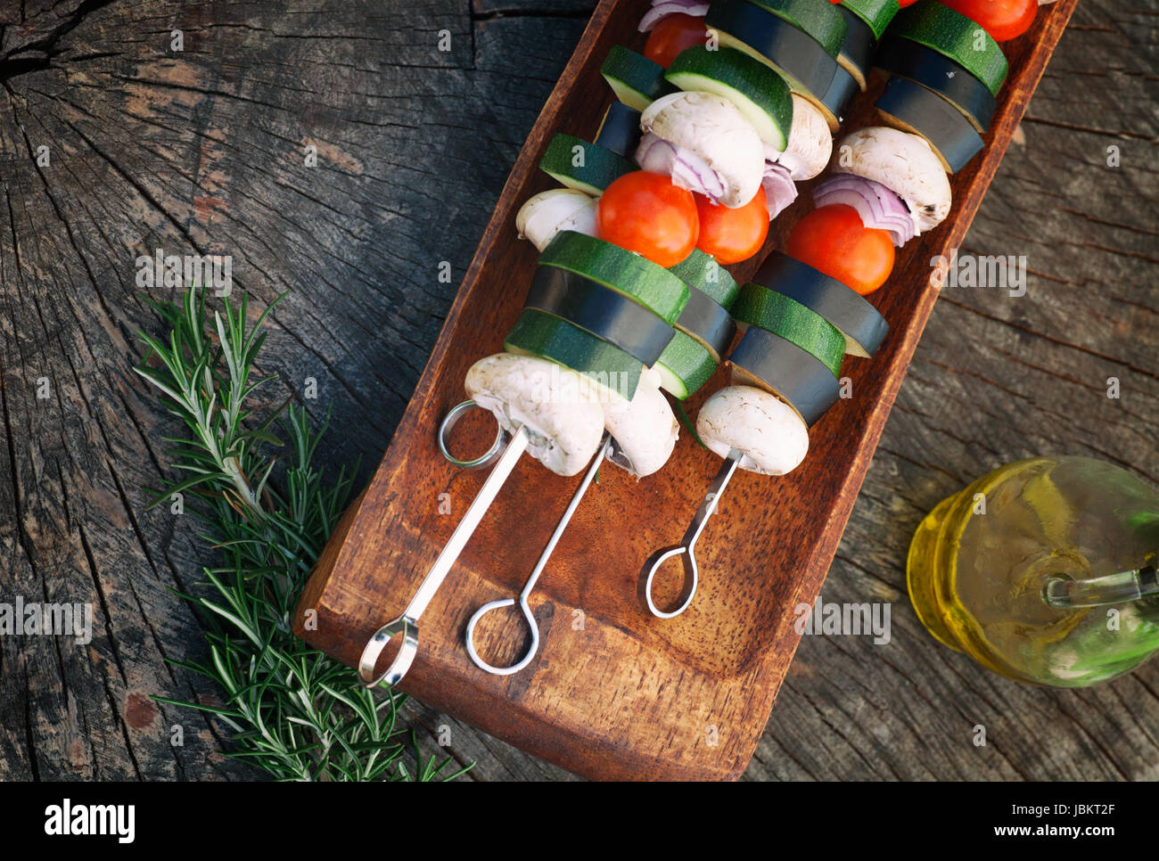 Printemps jardin barbecue. Brochettes de légumes avec les tomates cerises, la courgette, l'aubergine sur fond de bois Banque D'Images