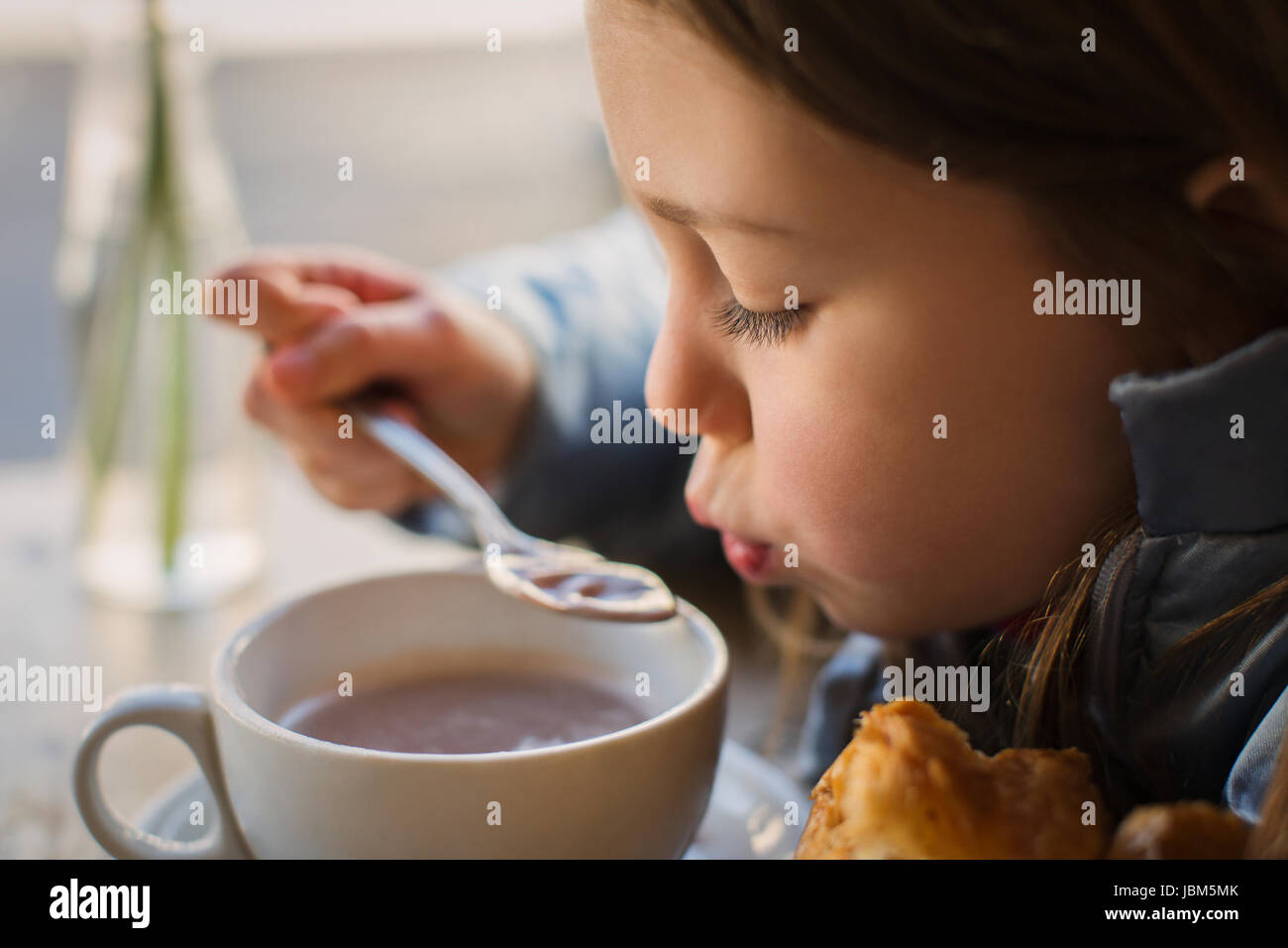 Close up girl blowing sur la soupe Banque D'Images