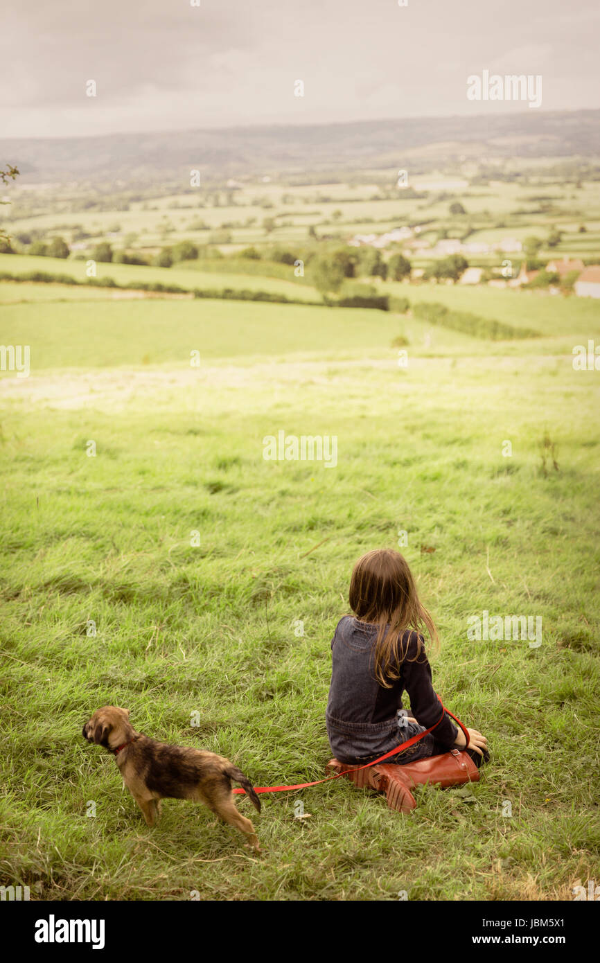 Fille avec petit chien en milieu rural, verte campagne field Banque D'Images