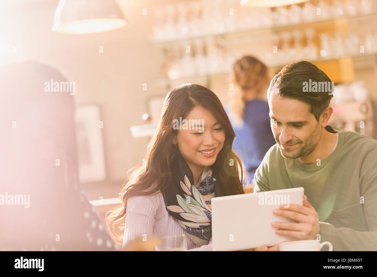 Friends using digital tablet in cafe Banque D'Images