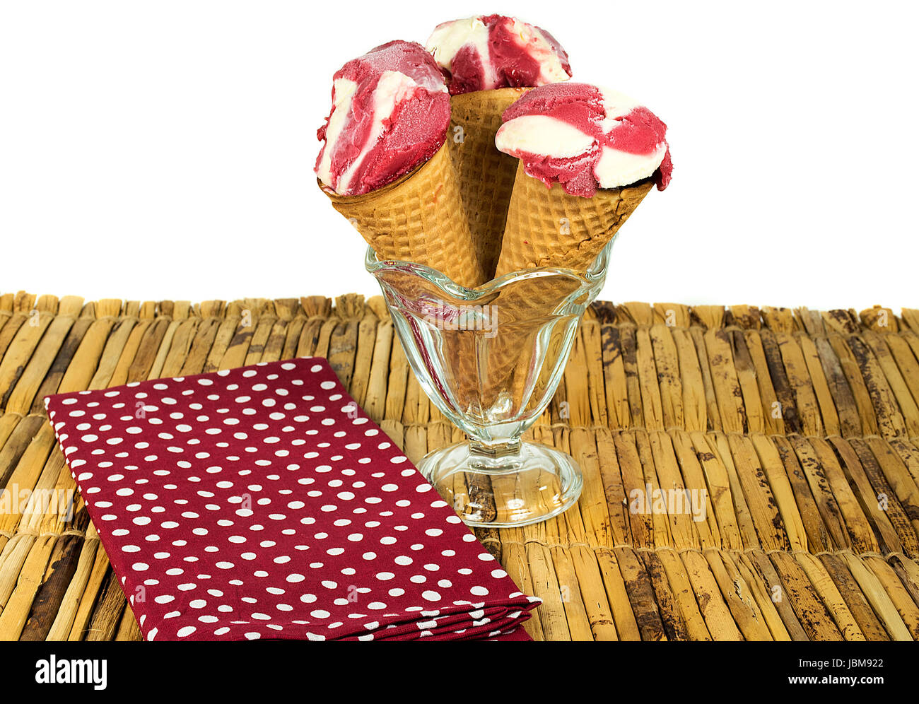 Sugar cones en sundae verre rempli de framboises congelées et crème vanille sur bambou set de table Banque D'Images