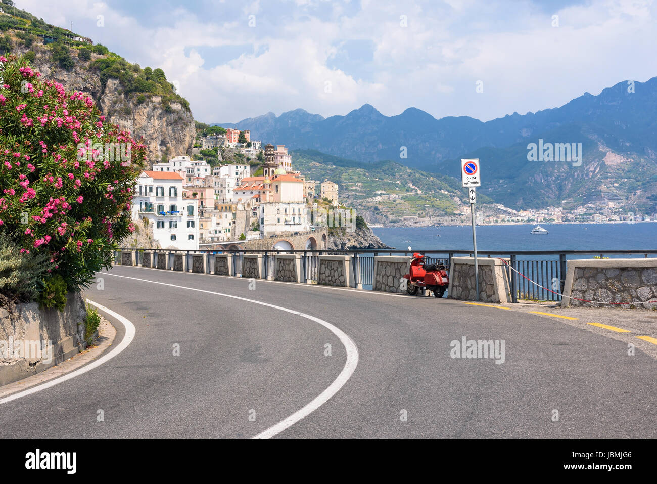 Scooter rouge par la route sur la côte amalfitaine avec en arrière-plan la ville de Atrani Banque D'Images