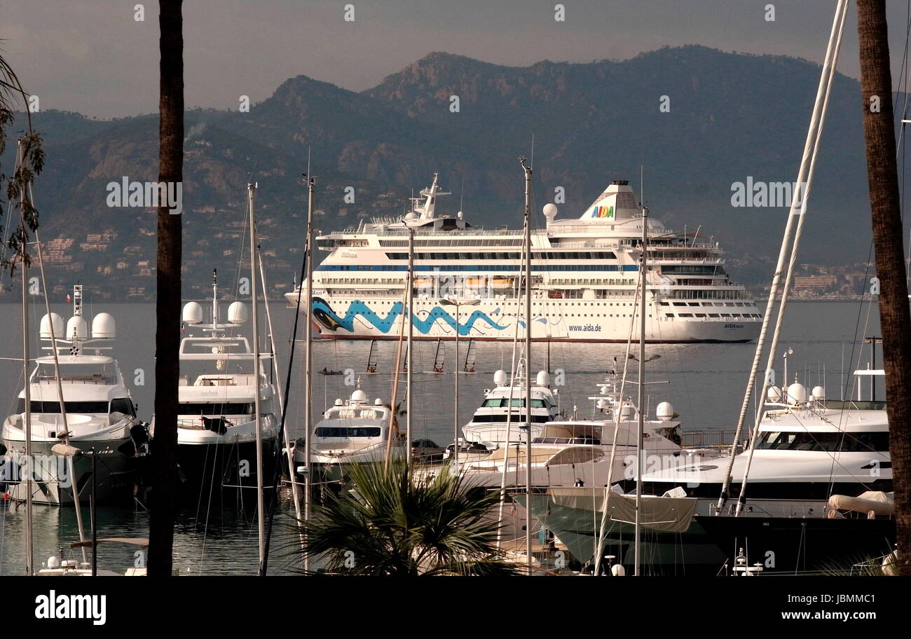 AJAXNETPHOTO. 2016. CANNES, FRANCE. - Côte D'AZUR RESORT - À L'OUEST À TRAVERS LA BAIE DE CANNES AVEC SUPER YACHTS ET VEDETTE À MOTEUR AMARRÉ DANS LA MARINA DE PORT PIERRE CANTO (premier plan), LE RECOUVREMENT DE CROISIÈRE AIDA AURA ANCRÉ DANS LA BAIE. PHOTO:JONATHAN EASTLAND/AJAX REF:GX160710 6478 Banque D'Images