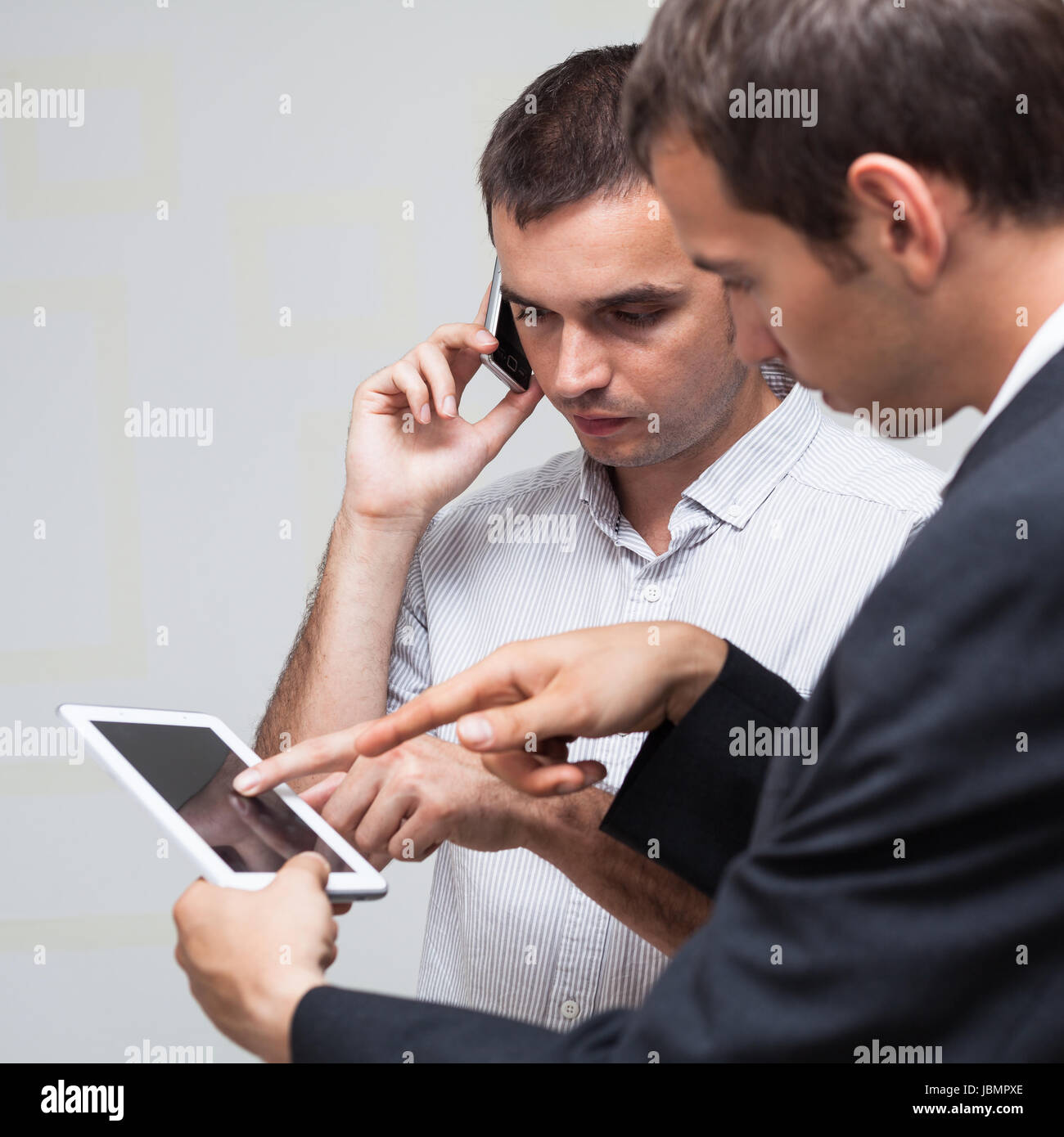 Deux hommes d'using digital tablet et smartphone. Banque D'Images