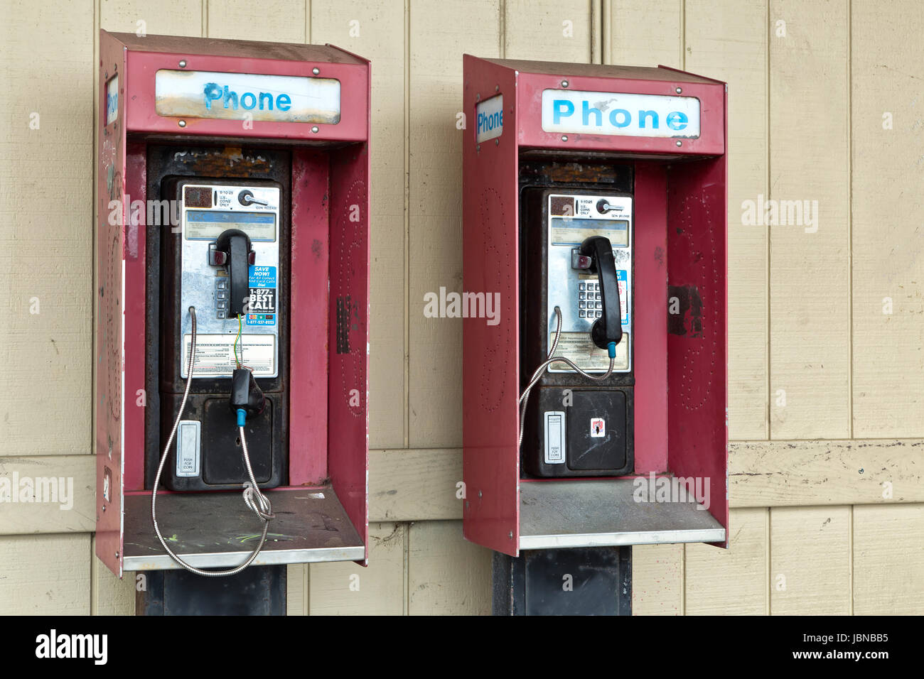 'Abandonné téléphones publics payants à pièces de monnaie avec la fente de sortie. Banque D'Images