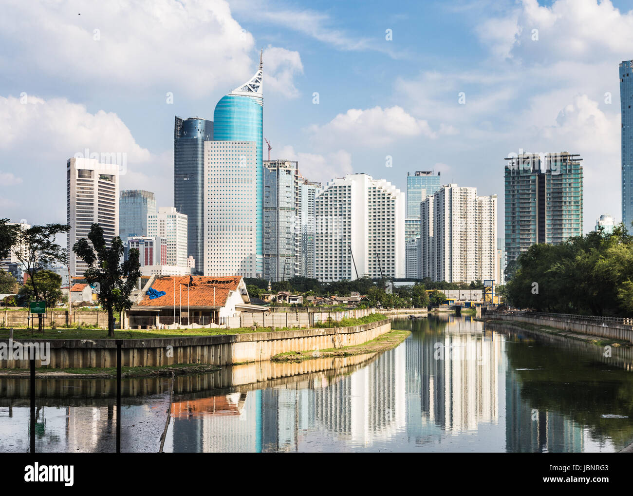Gratte-ciel, les immeubles de bureaux et hôtels de luxe towers reflète dans l'eau d'un canal à Jakarta sur une journée ensoleillée en Indonésie capitale Banque D'Images