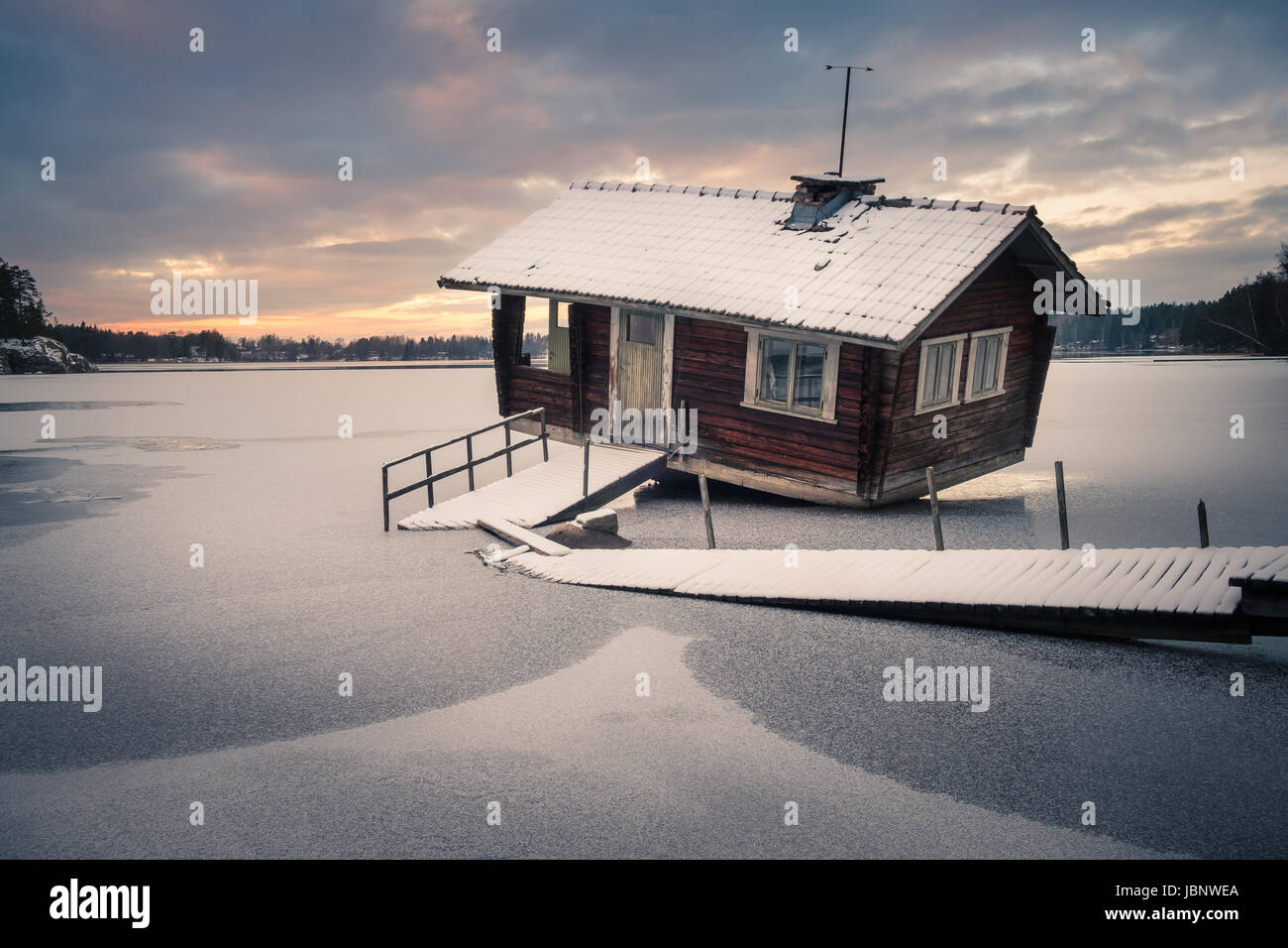 Cottage avec abandonné le coucher du soleil à soirée d'hiver en Finlande Banque D'Images