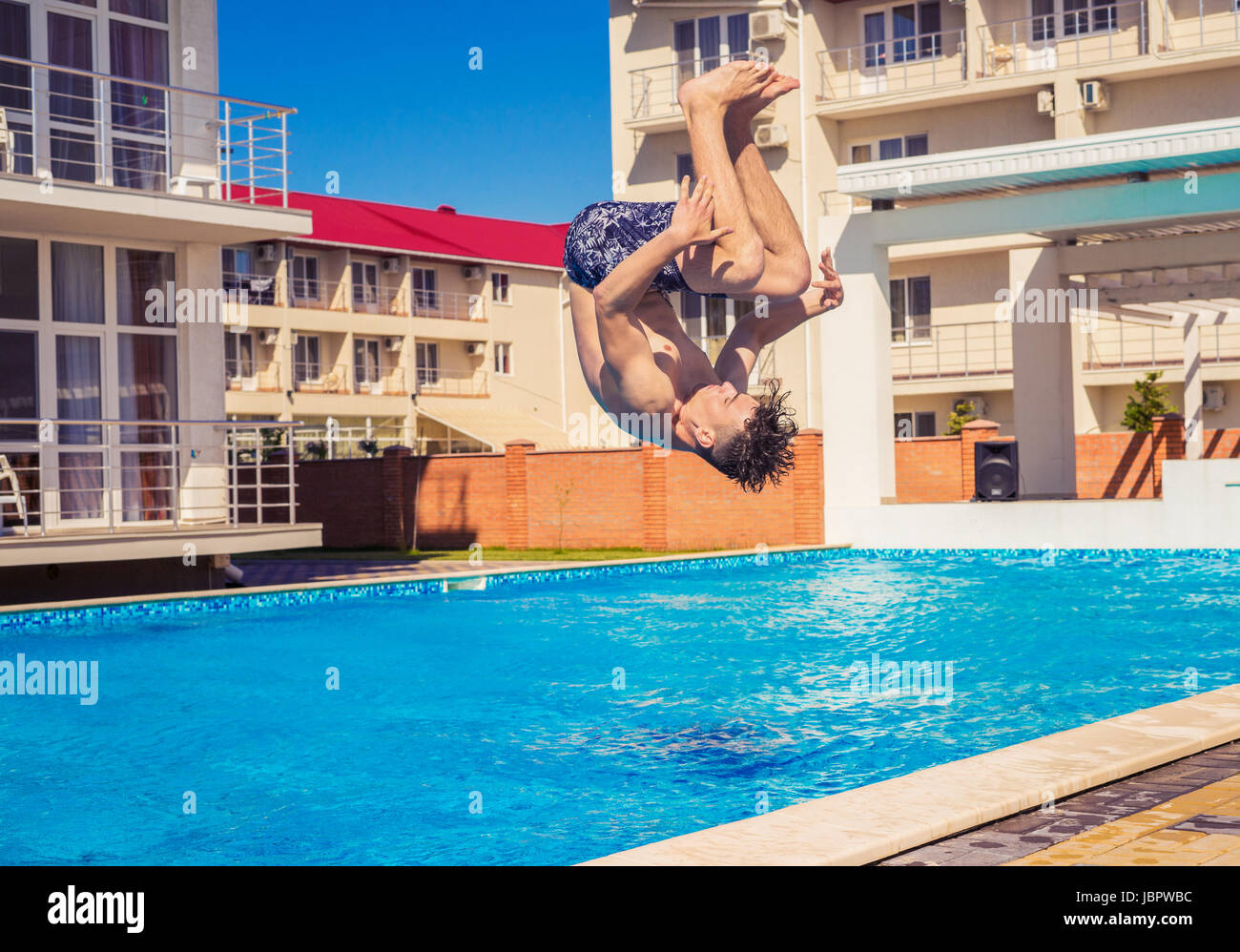 Homme Somersaul ou retournez plonger dans une piscine Banque D'Images