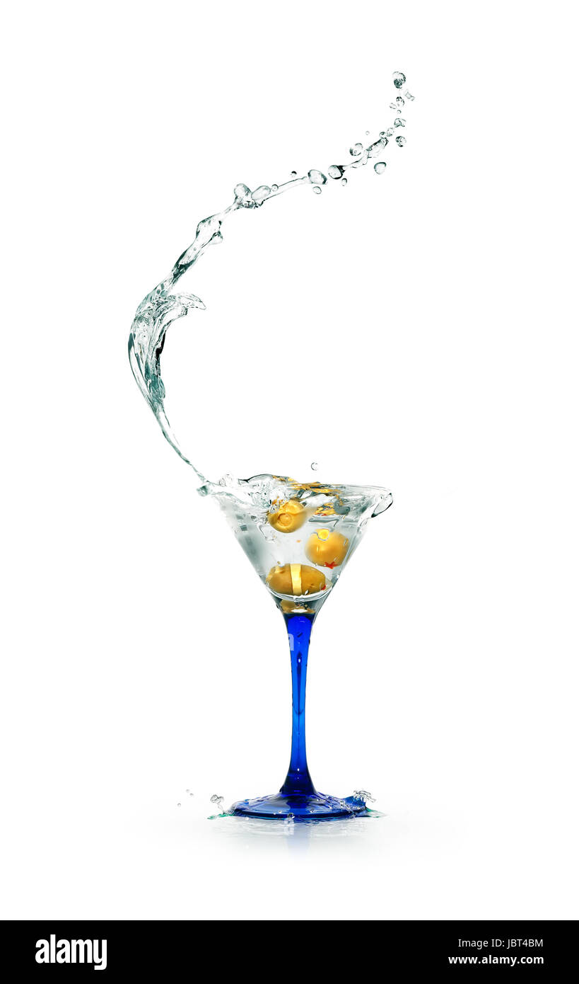 Verre à cocktail élégant avec des éclaboussures de liquide et olives noires sur fond blanc Banque D'Images