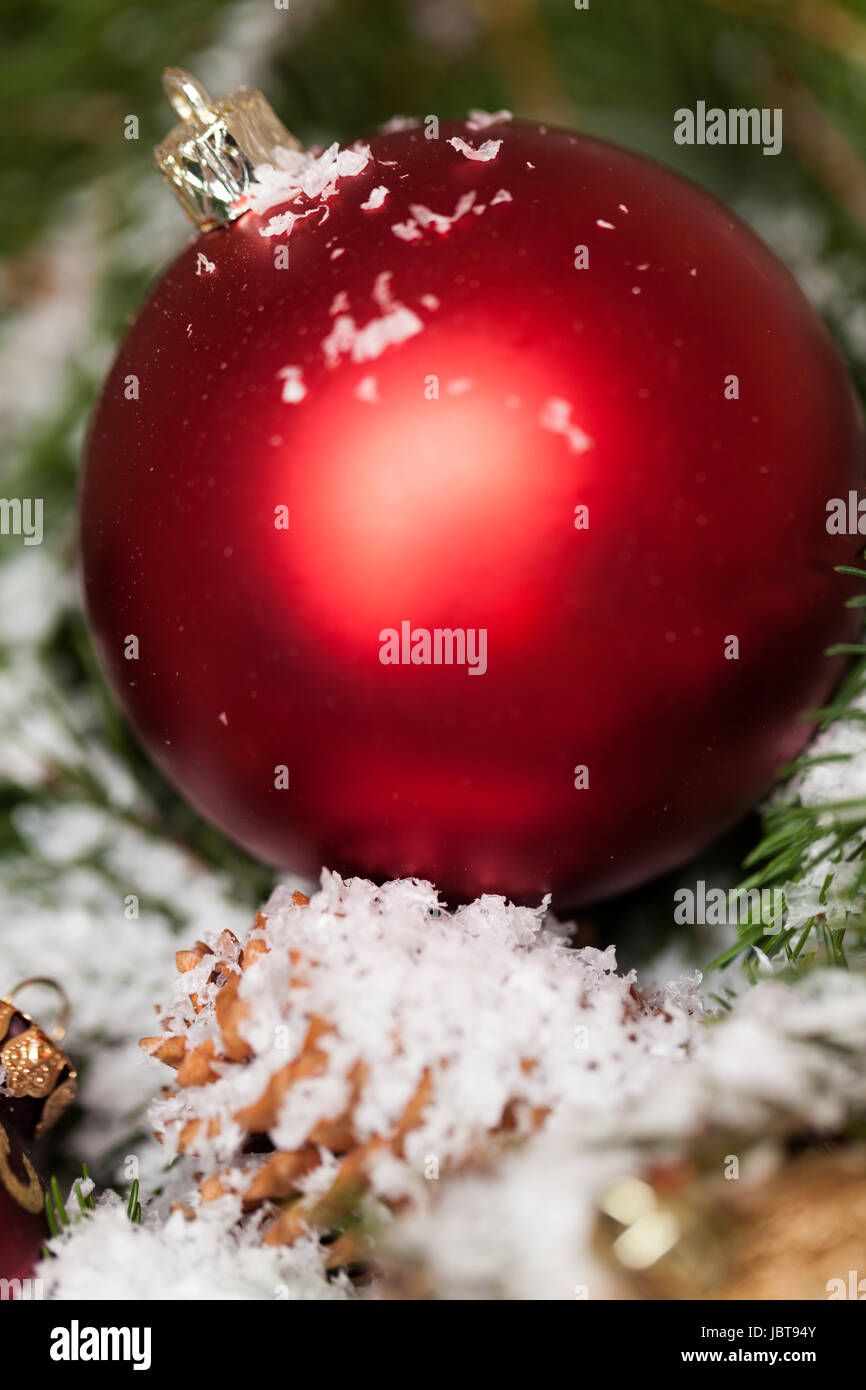 Rote Weihnachtskugeln Zapfen Tannenzweigen zwischen und mit Schnee bedeckt Détail Macro als Banque D'Images