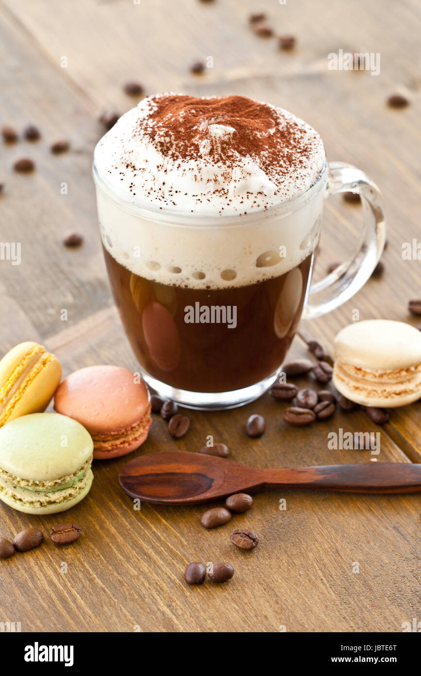 Eine Tasse Kaffee mit Milchschaum und bunte Macarons Banque D'Images