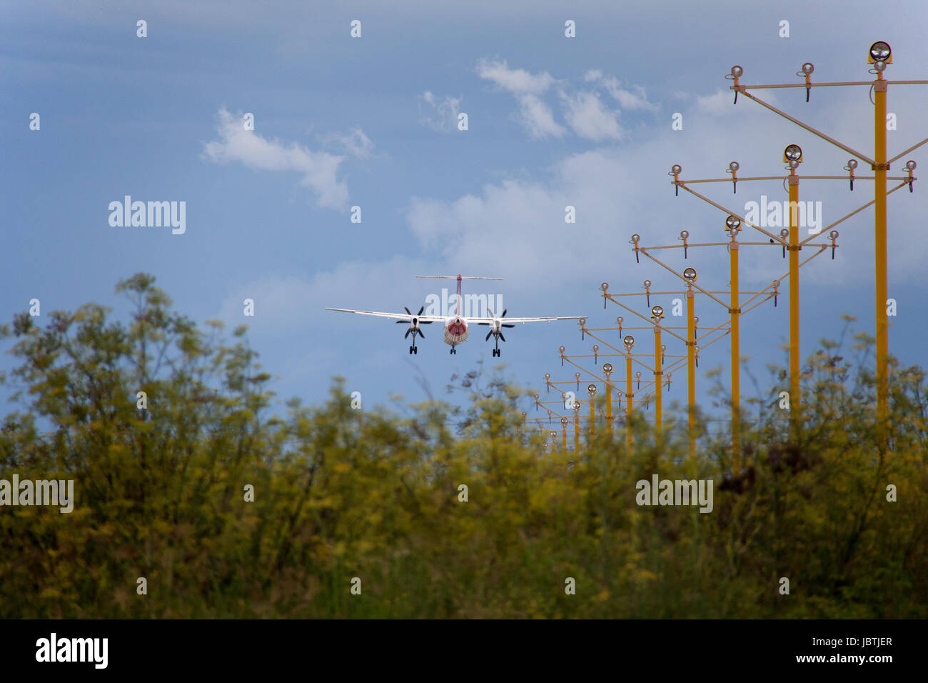 Bombardier Dash 8 de Qantas à l'atterrissage à l'aéroport de Sydney, s'approchant plus de verdure (fenouil) et des lumières stroboscopiques airport Banque D'Images