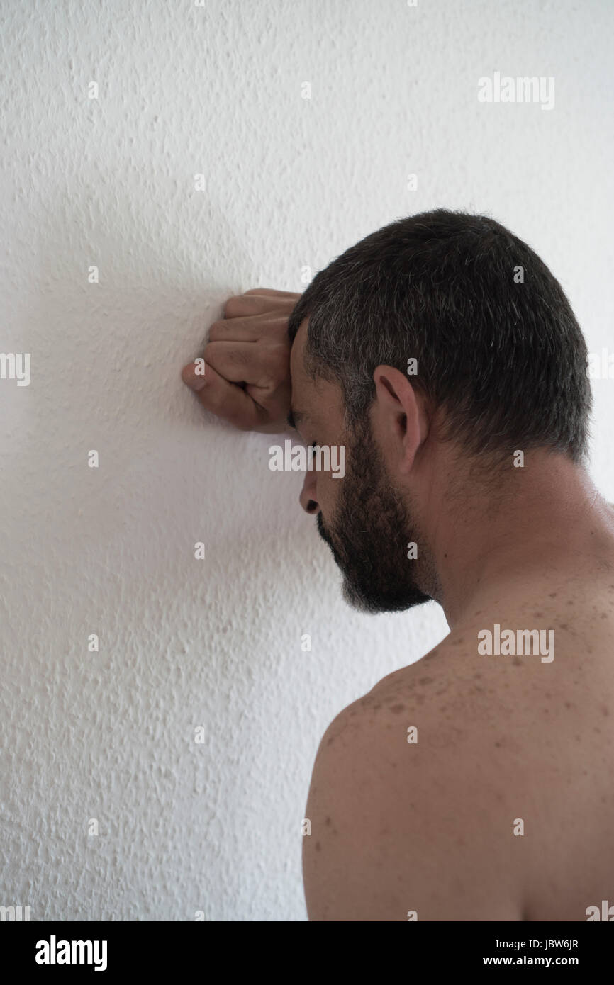 L'homme eatsern milieu déprimé appuyé contre le mur Banque D'Images