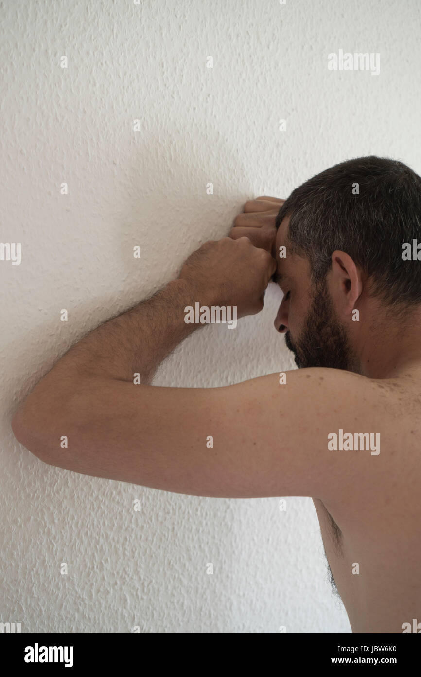 L'homme eatsern milieu déprimé appuyé contre le mur Banque D'Images