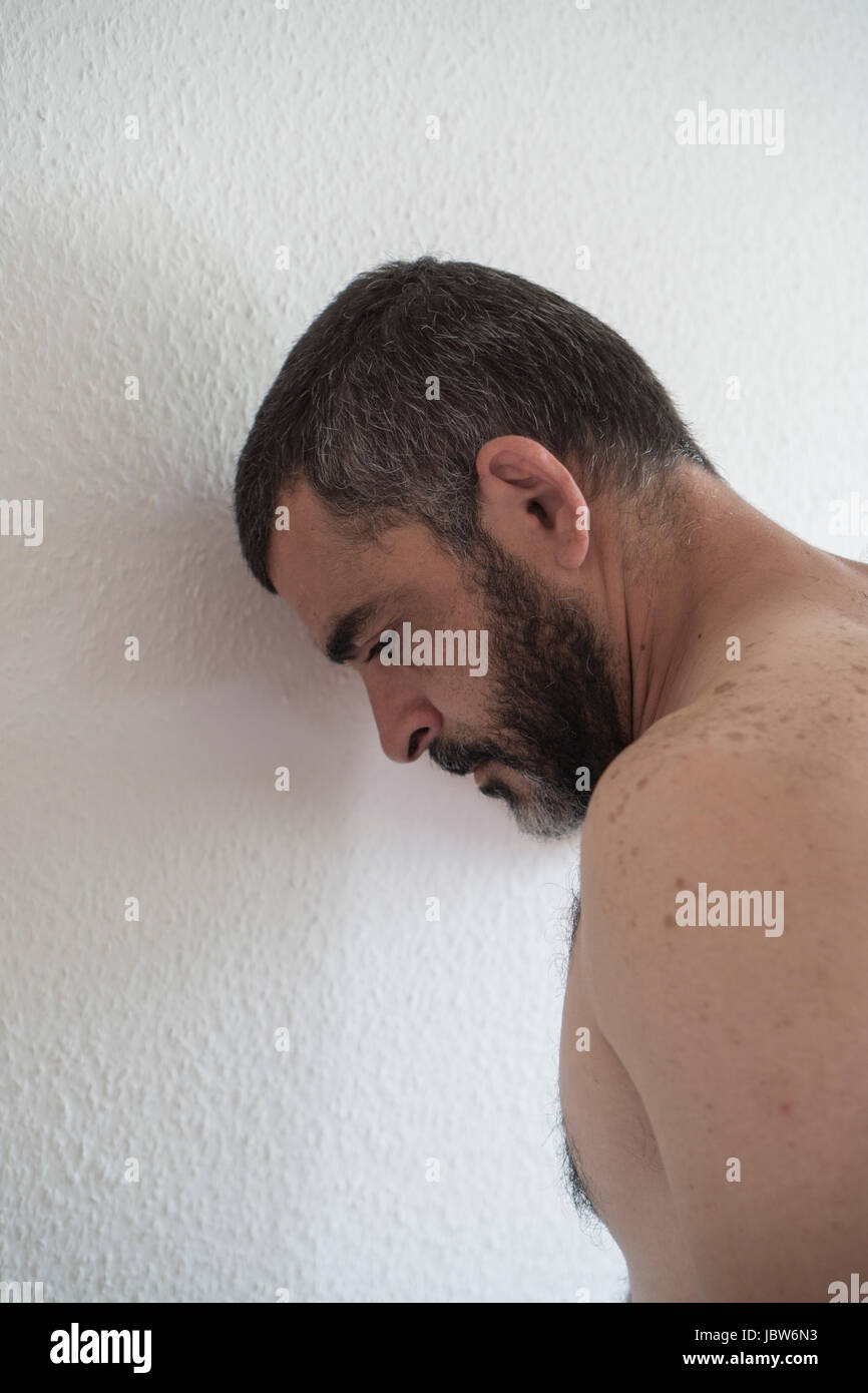 L'homme eatsern milieu déprimé appuyé contre le mur Banque D'Images