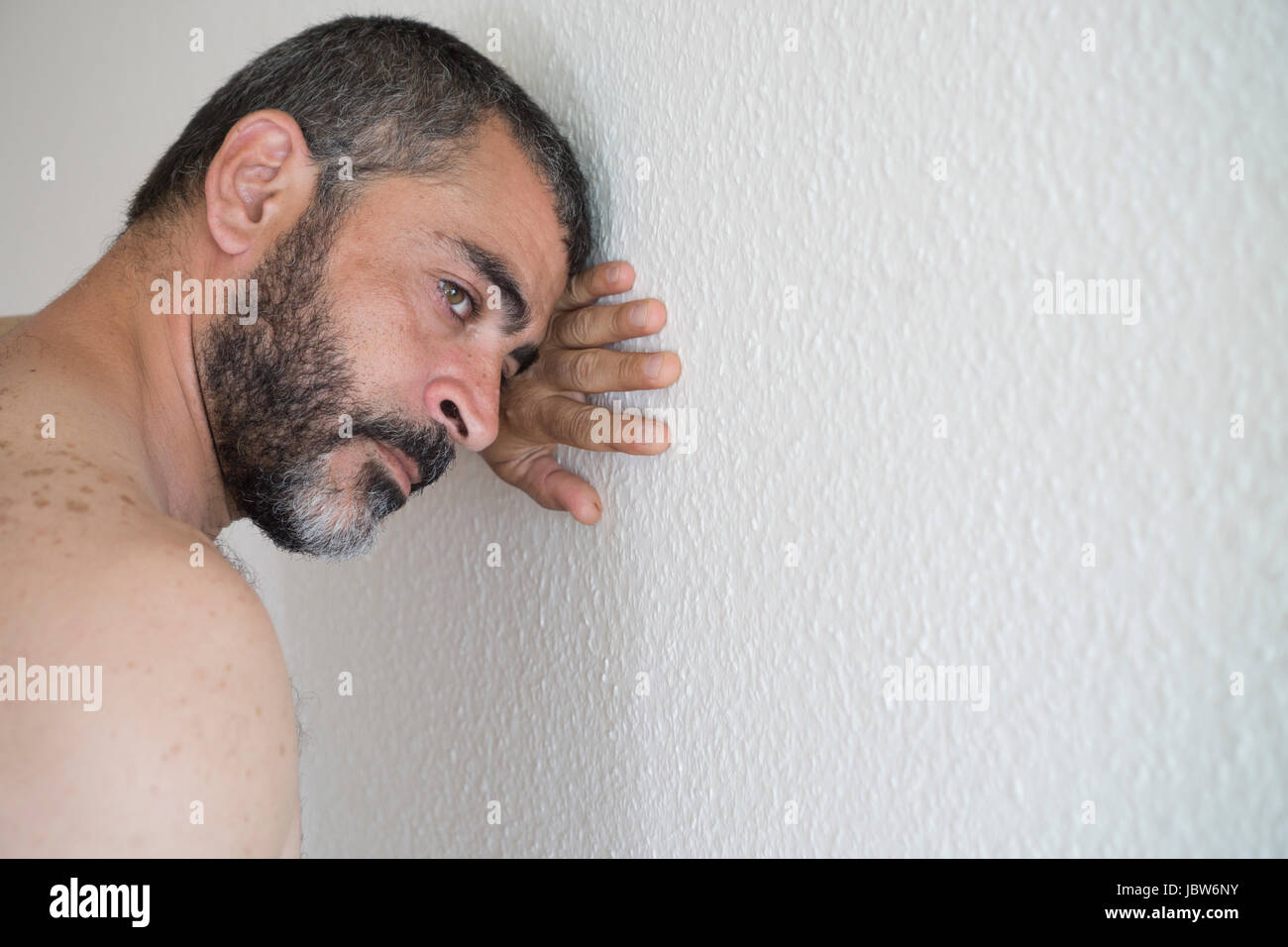 L'homme eatsern milieu déprimé appuyé contre le mur Banque D'Images