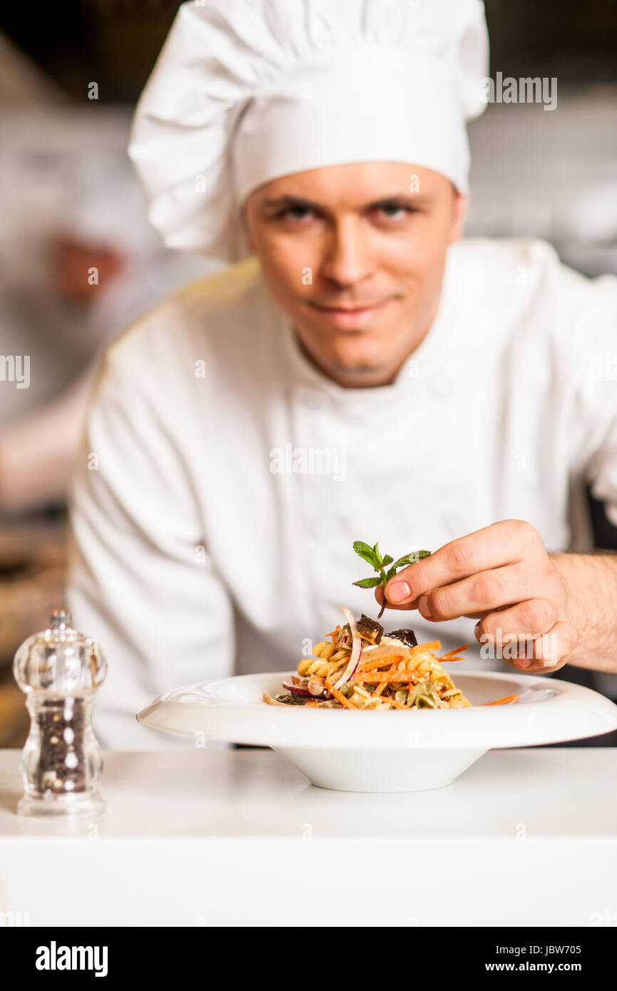 Chef d'ajouter une touche finale à délicieuse salade Banque D'Images