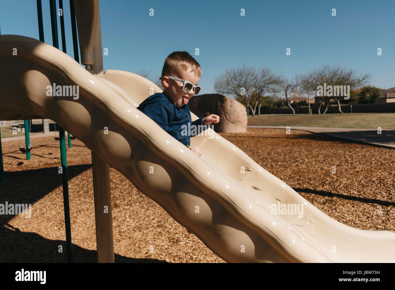 Boy on playground slide Banque D'Images