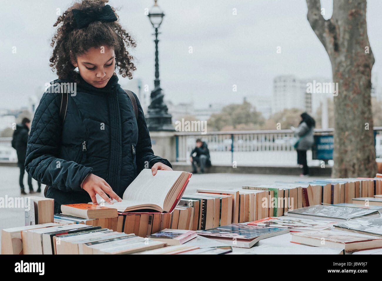 Un enfant de 10 ans est parcourt second hand books à Southbank Center, marché du livre de Londres. Banque D'Images