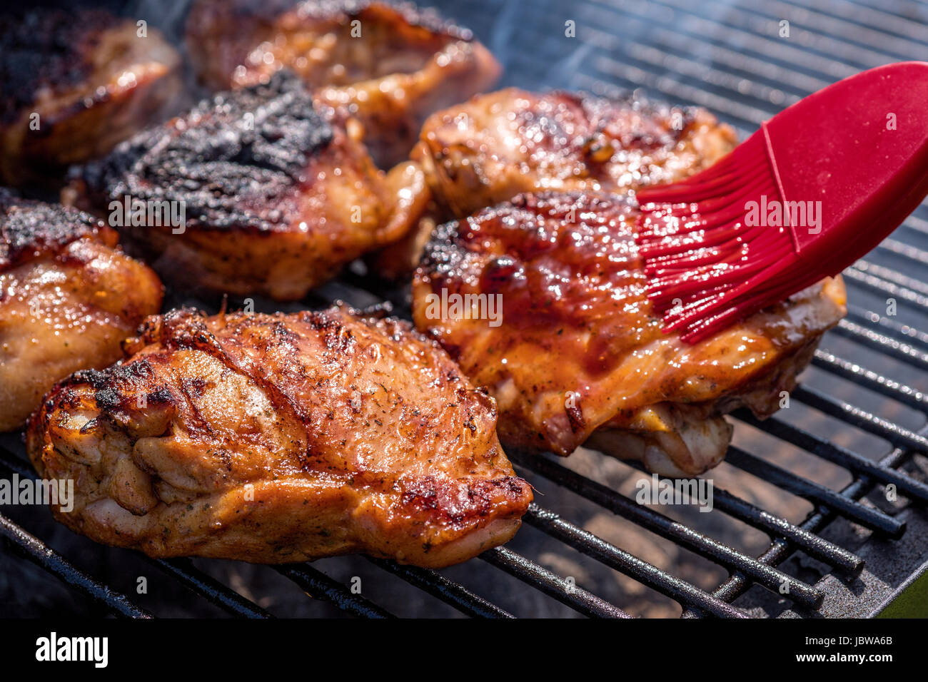 Cuisse de poulet grillé sur le grill en flammes Banque D'Images