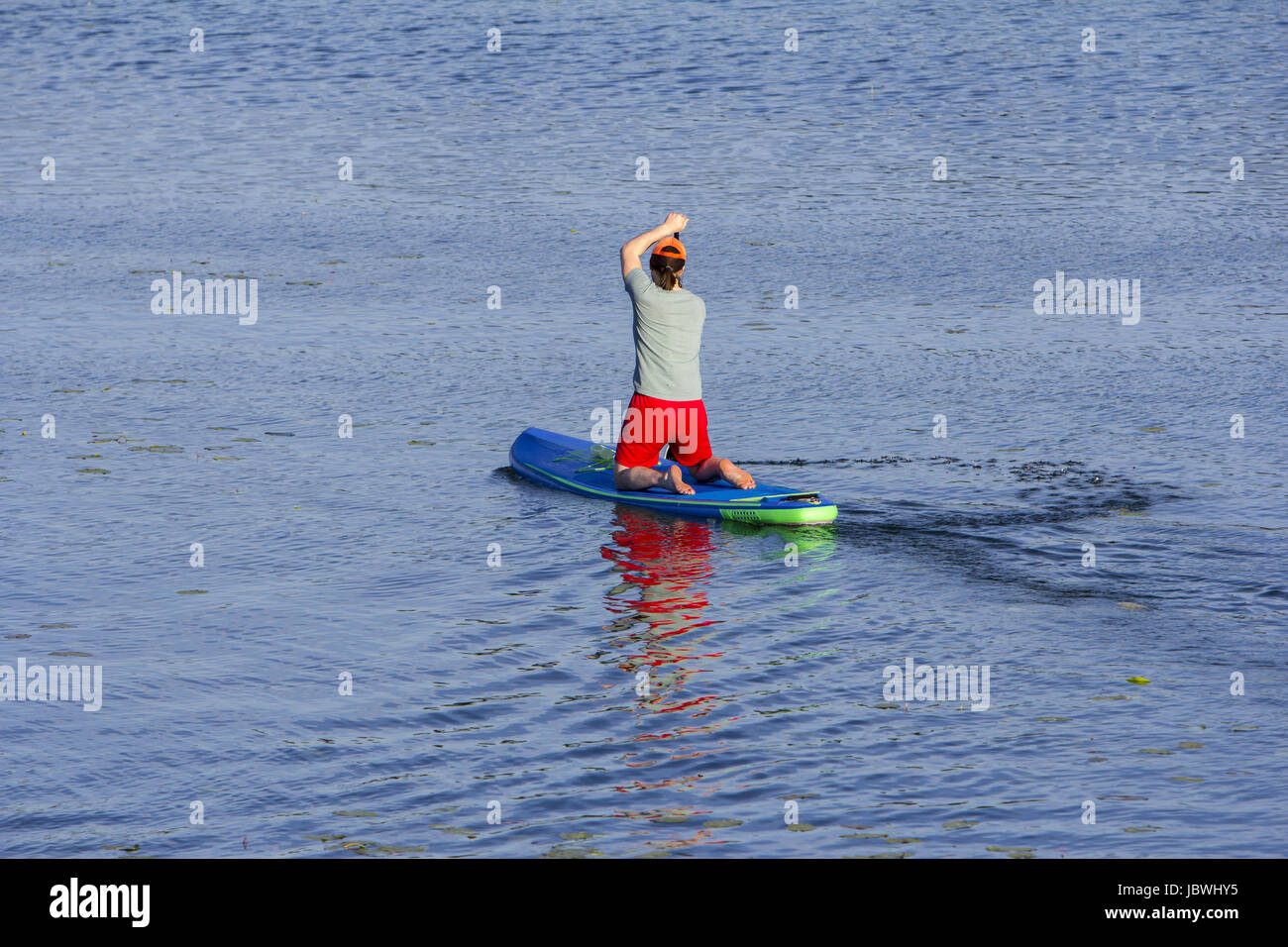 Man on Paddle Board paddling out au lac Banque D'Images